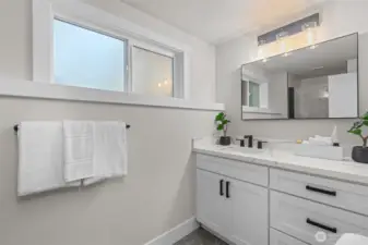 Updated 3/4 bath with quartz vanity and modern finishes for added convenience.