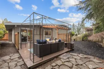 Generous deck with built-in seating and covered area, offering versatile outdoor living space in a peaceful setting.ate backyard retreat featuring expansive deck space and mature landscaping for added privacy.