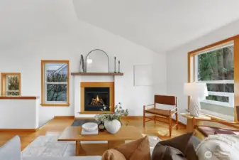 Oak hardwoods shine under vaulted ceilings lit by abundant natural light pouring in through east, south, and west windows.