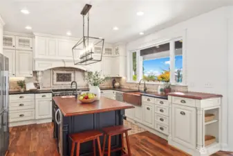 High-qualify cabinetry, hammered copper sinks, soapstone counters, custom lighting, Wolf stove/range are some of the features in this beautiful kitchen that overlooks the water views.