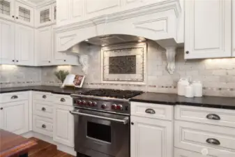 This warm and inviting kitchen boasts a 6-burner Wolf stove/range, back-lit quality cabinets, newer Fisher-Paykel fridge, wine cooler and island seating.