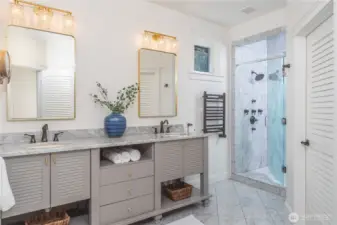 The primary bathroom has dual sinks, heated marble floors, a spacious shower with mulitple shower heads, private water closet and built-in linen closet.
