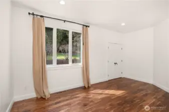 The main level guest bedroom enjoys west-facing views of the backyard landscape and waterfall.
