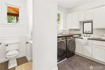 The wonderful utility room has nearly-new washer/dryer, sink, spacious storage cabinets, built-in ironing board and a one-quarter bath.