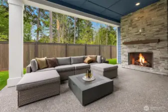 Covered patio with exterior fireplace backs to private greenbelt