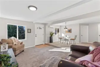 A/Main Floor: Living Room w/Windows overlooking the front door. New Carpet, Laminate Entry, New White Painted Millwork Trim and Doors. Notice the mini-split unit that provides heat and AC for the main floor.