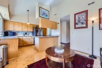 The open-design kitchen is appointed with gorgeous slab granite counters, customized oak cabinets with pull-outs, a newer Samsung fridge, GE Profile dishwasher, and a STL range.