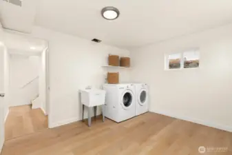 Oversized laundry room with sink; washer and dryer stay