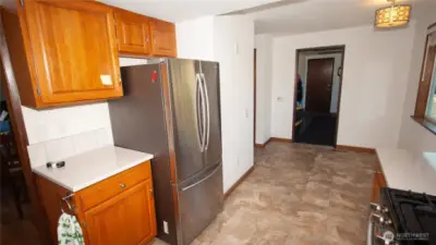 This angle shows the depth of the kitchen to the back bonus room which is a mudroom with it's own door access by garage door. There is kitchen table space with a sizable viewing window.