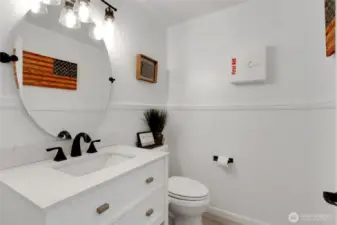Main level bathroom completely updated with new vanity, faucet, lighting, toilet, and floors