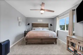 Primary bedroom with new carpet, moulding, ceiling fan, doors and moulding.