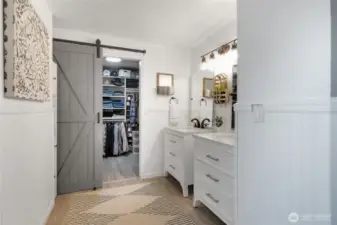 Primary bathroom with new vanities, lighting, floors, & faucets. Walk in closet w/new barn door and closet organizer.