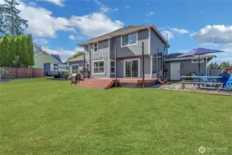 View of RV parking on left and gravel patio with fire pit. Grass is enhanced.