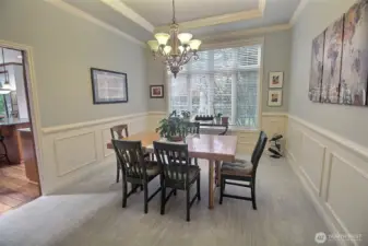 Wainscoting surrounds this Formal Dining Room, trimmed off with crown & cove molding, a beautiful chandelier and steps from the grand kitchen.