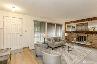 Main living room with wood burning fireplace & lots of light .