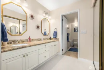 Ensuite bathroom with granite dual-sink vanity, soft lighting, and ample storage.