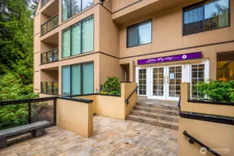 Main entrance to the St. Moritz A Building with double glass doors and purple canopy signage.