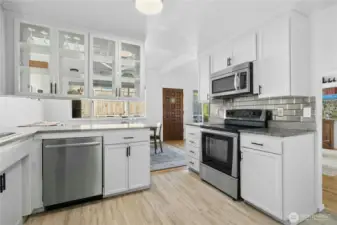 Kitchen with LVP flooring and stainless steel appliances.