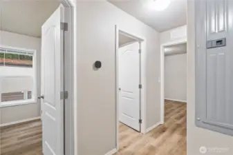 Interior hallway connecting bedrooms, bathroom, & laundry.