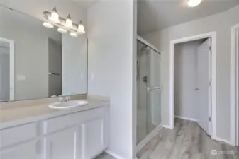 Capture the view of the primary stand-up shower, accompanied by an adjacent discreet door leading to the private toilet room, offering convenience and privacy. Additionally, the spacious walk-in closet stands ready to accommodate your wardrobe needs, completing the picture of comfort and functionality.