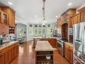 Custom kitchen with stainless appliances, lots of prep and storage space opens to the cozy breakfast nook.