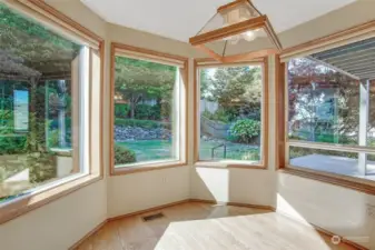 A wonderful breakfast nook is nestled in a bay of windows overlooking the colorful back yard.