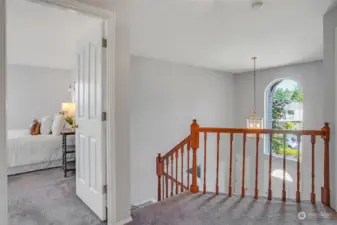 Upstairs landing looking out to the two-story foyer and pretty window.