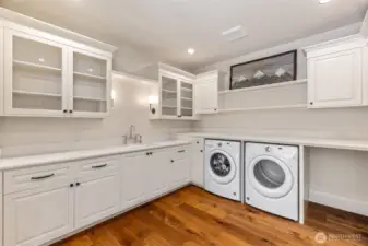 Main laundry room featuring ample space, with a large pantry conveniently located just out of view to the right.