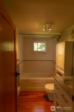 Modernized bath with newer tile, door, and vanity.