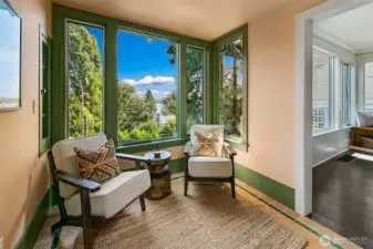 This covered porch was updated to be fully enclosed with heated tile floors and views of the lake and mountains.