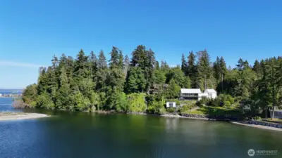Set on a half-acre of lush, curated gardens, this home opens to 82 feet of pristine shoreline.