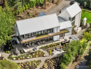 TTwo serene primary suites rest on either side of a light-filled breezeway, offering comfort and privacy. Curated gardens and lawn blend seamlessly with shoreline ecology, while a sleek metal roof and living decks elevate the home’s coastal design.