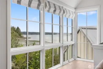 The second primary suite enjoys serene water views.