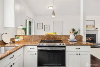 Slide-in glass cooktop range with built-in exhaust fan. Deep single sink in undermount stainless steel.