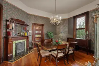 From the living room and through the double disappearing sliding doors is the formal dining room. A functional (though seldom used) wood burning fireplace and victorian mantle are the centerpiece in this gorgeous room. Again, the large pane windows and stunning views of the grounds seem to draw the outdoors, in. a ‘servers’ door to the kitchen sits near the back of the large room.