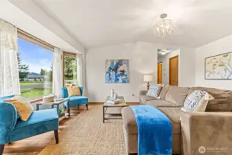 The living area lives large with high ceiling, LVP flooring and lots of natural light.