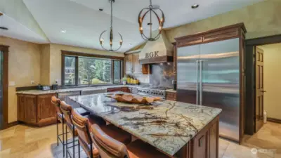 Stunning kitchen features Canyon Creek rustic alder cabinets, granite island and counters, top-of-the-line Subzero and Wolf appliances and heated travertine floors.