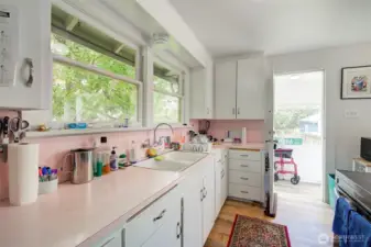 Galley kitchen with large windows.