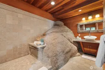 The 3/4 bath on the lake level has the rock protruding into the room as part of the large, tiled shower.