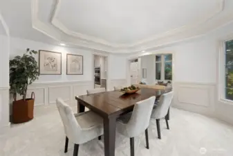 Well-appointed dining room with tray ceiling, detailed wainscoting, and generous windows, conveniently located just steps from the kitchen—ideal for effortless serving and entertaining.