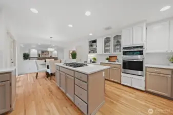 Open-concept kitchen with refinished hardwood floors, expansive island, and seamless flow into the adjacent living spaces—ideal for everyday living and entertaining alike.