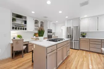 Updated kitchen showcasing GE Profile stainless steel appliances, including a gas range, built-in microwave, and oven, paired with crisp cabinetry and modern finishes.
