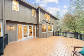 Expansive main-level composite deck with seamless indoor–outdoor flow through French doors, ideal for entertaining or everyday relaxation amid serene natural surroundings.