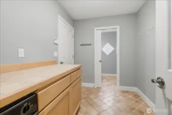Mud room between the garage (door on left) and the kitchen with added storage and half bath at the far end.
