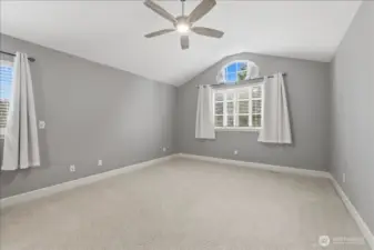 Spacious primary bedroom is located upstairs at one end of the home.