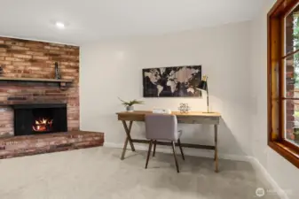 A wood burning fireplace with an rustic brick surround creates a comfortable environment in the lower-level recreation room