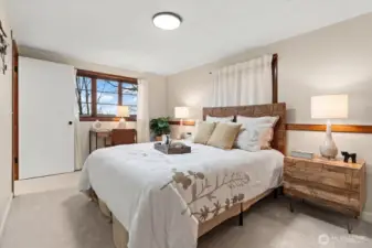 Plush new carpeting, fresh interior paint, and large view window create a light and bright atmosphere in lower-level bedroom