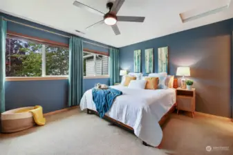 Step into this restful retreat! The primary suite has a wall of windows against a steely blue contemporary wall paint for a restful night's sleep.