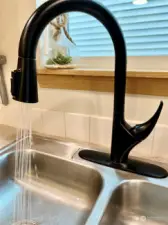 You'll note the stunning matte black upgrades for all of the fixtures and hardware throughout the house. Here is the kitchen faucet with pull-down dual-spray head.