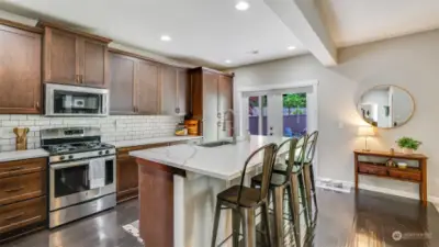 Kitchen boasts rich cabinetry, granite counters, stainless steel appliances, and recessed lighting.